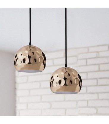 Een koperen hanglamp in een sfeervolle setting waar de keuze tussen warm wit of neutraal wit licht het interieur bepaalt.