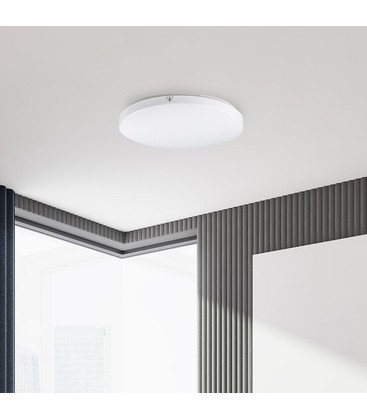Ronde LED plafondlamp gemonteerd in een moderne ruimte voor egale lichtverspreiding.
